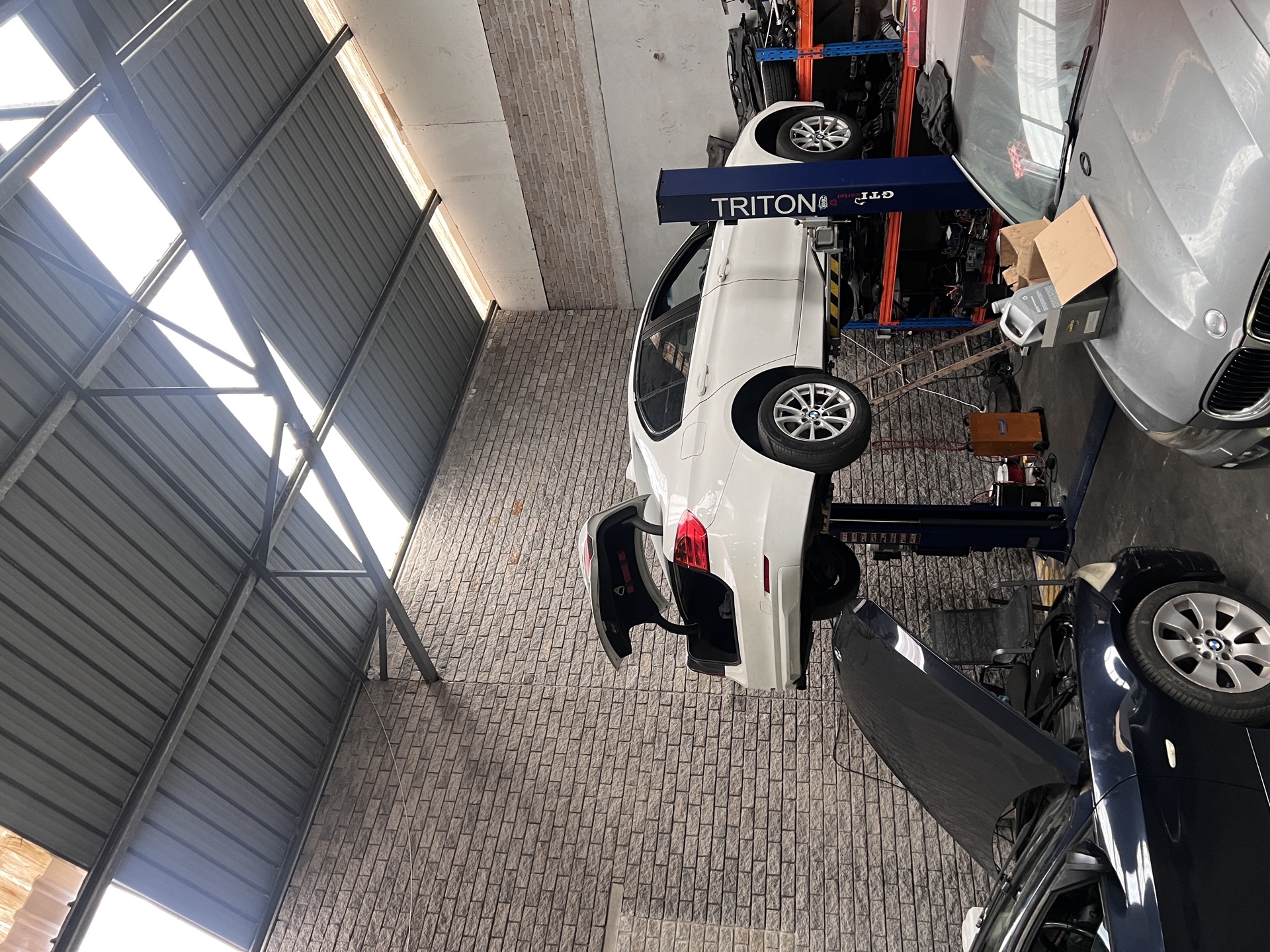 Inside Colmad Auto workshop in Killarney Gardens — BMWs on lifts, professional mechanic equipment